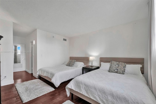 bedroom featuring dark hardwood / wood-style flooring and a textured ceiling