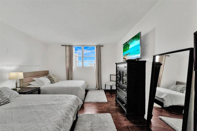 bedroom featuring a textured ceiling and dark wood-type flooring