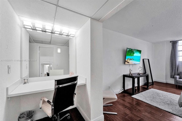 office space with a paneled ceiling and dark wood-type flooring