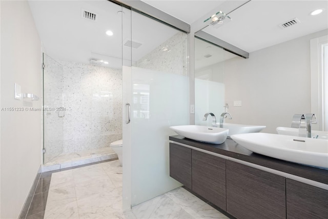 bathroom with tile floors, toilet, dual bowl vanity, and walk in shower