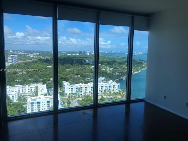 empty room featuring expansive windows, plenty of natural light, and tile flooring