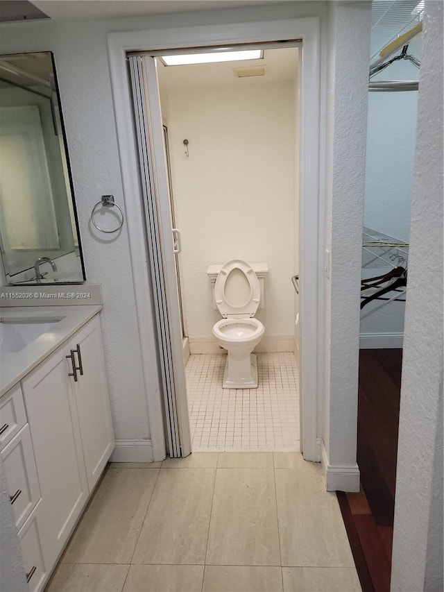 bathroom featuring vanity, toilet, and tile patterned floors