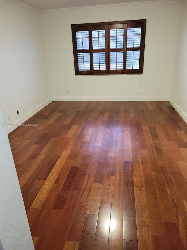 spare room featuring hardwood / wood-style flooring and crown molding