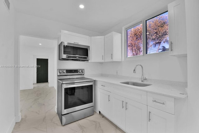 kitchen featuring light stone countertops, white cabinetry, electric stove, sink, and light tile floors