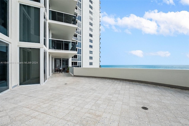 view of patio featuring a water view and a balcony