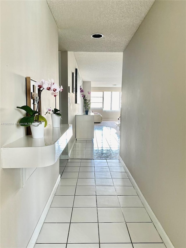 hallway featuring light tile patterned floors and a textured ceiling