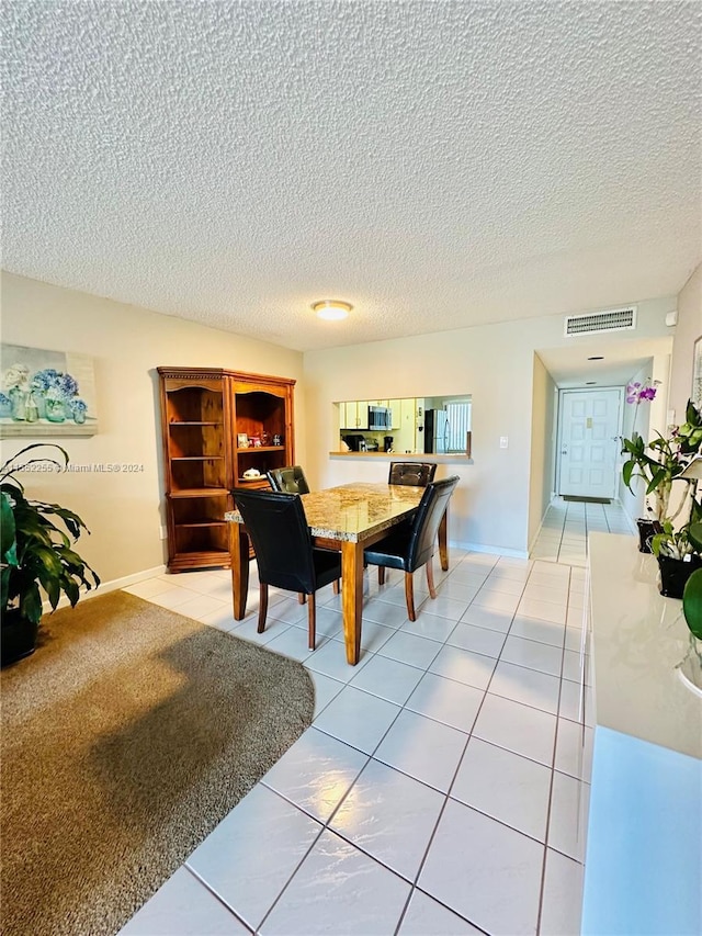 dining area with light tile patterned flooring and a textured ceiling