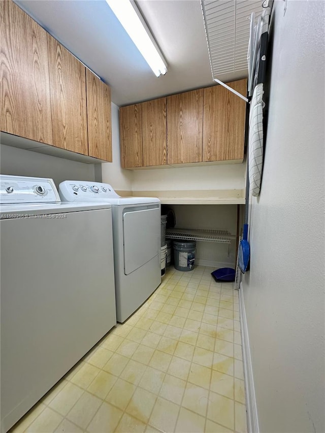 laundry room with cabinets and washing machine and clothes dryer