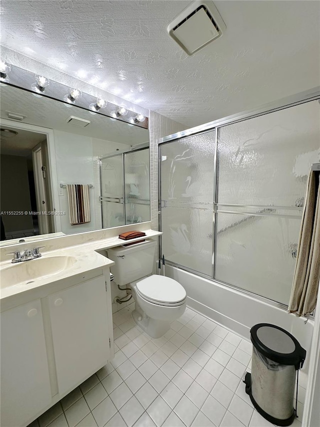 full bathroom featuring tile patterned flooring, toilet, enclosed tub / shower combo, and a textured ceiling