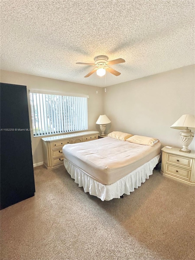 bedroom featuring a textured ceiling, light colored carpet, and ceiling fan