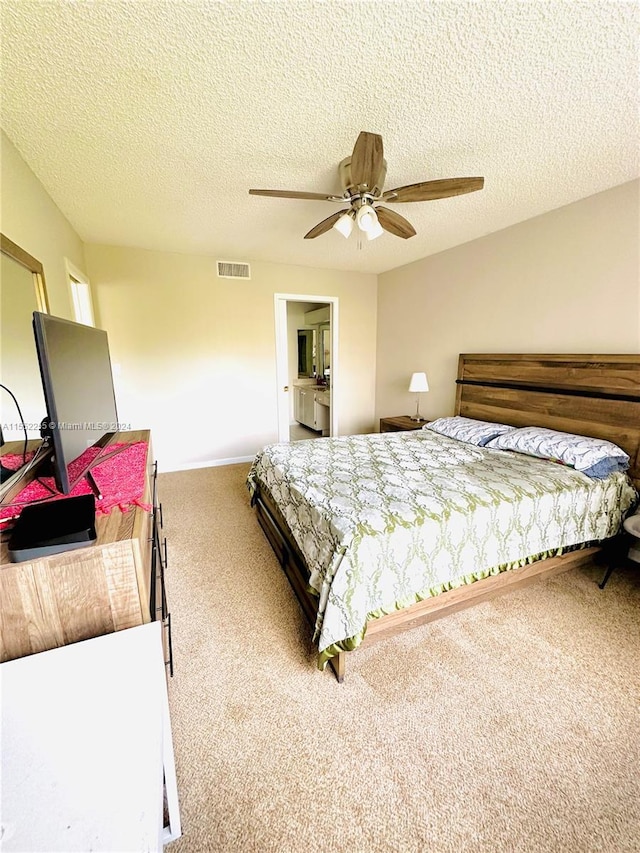 carpeted bedroom featuring ceiling fan and a textured ceiling