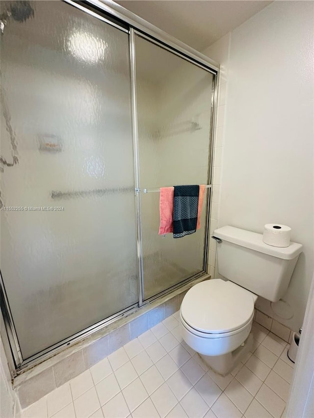 bathroom with tile patterned floors, toilet, and walk in shower