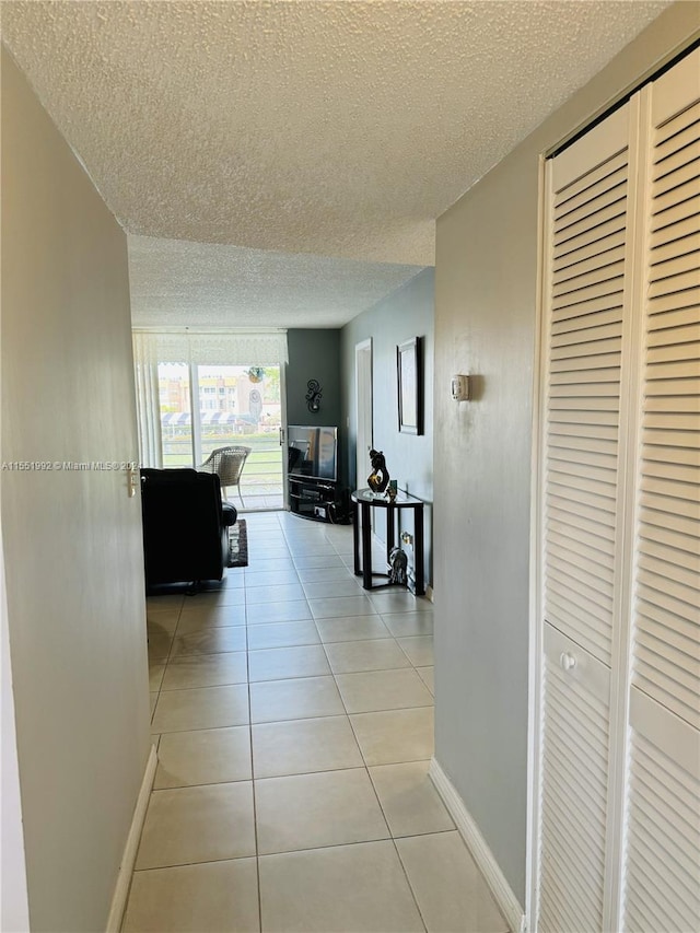 hallway featuring light tile floors and a textured ceiling