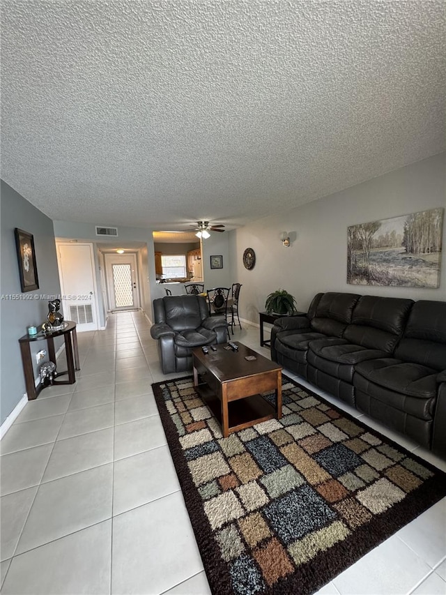 tiled living room featuring ceiling fan and a textured ceiling