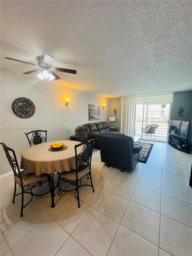 dining room with light tile flooring, ceiling fan, and a textured ceiling