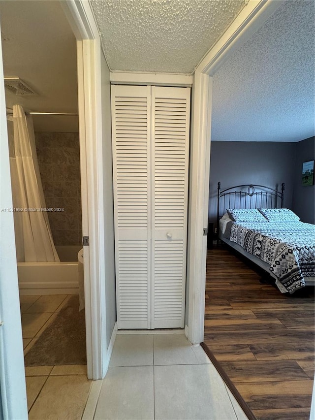 bedroom with hardwood / wood-style floors, a closet, and a textured ceiling