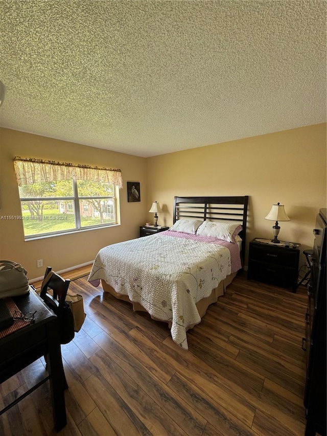 bedroom with a textured ceiling and dark hardwood / wood-style flooring