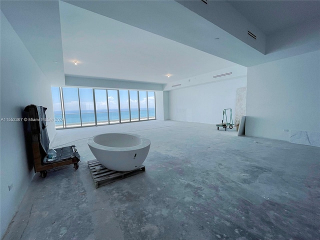 unfurnished living room featuring a water view