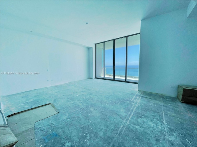 unfurnished room featuring a water view