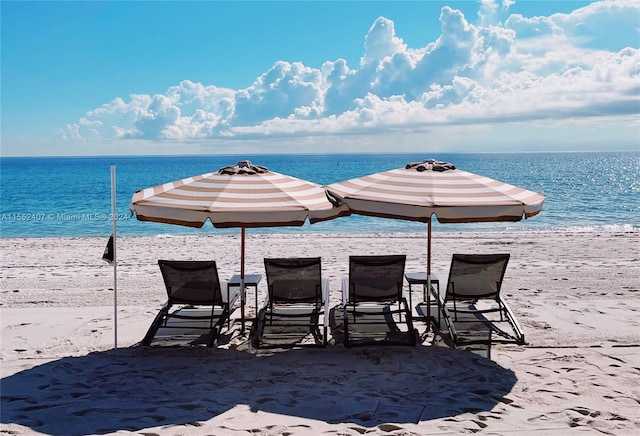 view of patio / terrace with a water view and a view of the beach