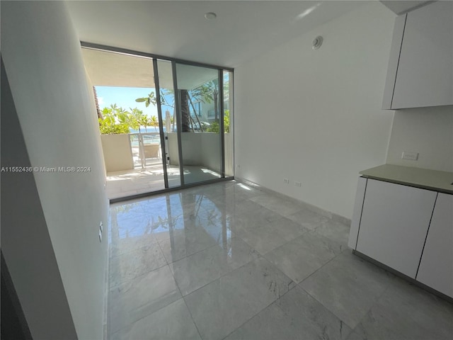 interior space featuring floor to ceiling windows and light tile floors