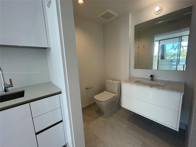 bathroom with tile flooring, toilet, and vanity with extensive cabinet space