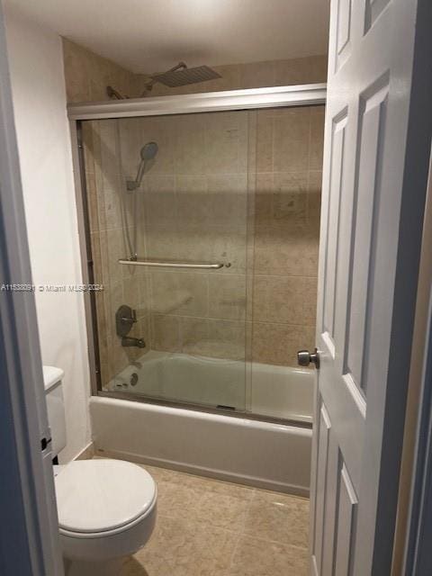 bathroom with enclosed tub / shower combo, tile flooring, and toilet