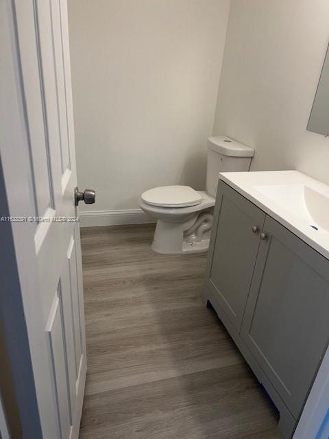 bathroom featuring hardwood / wood-style floors, toilet, and vanity