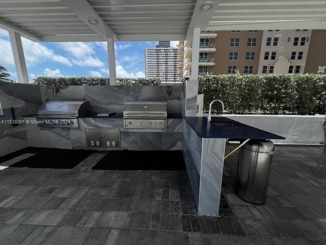 view of terrace with a grill and an outdoor kitchen