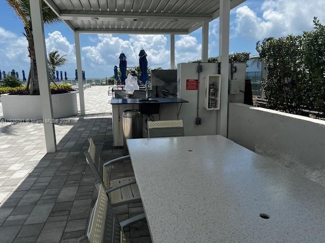 view of patio with a water view and exterior bar