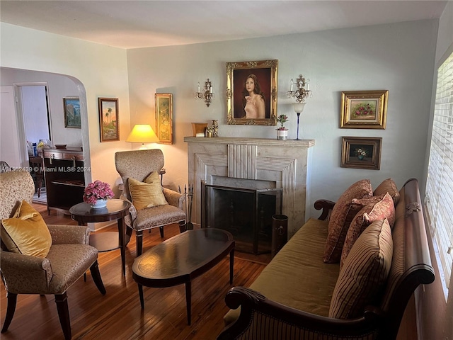 sitting room with a brick fireplace and hardwood / wood-style floors