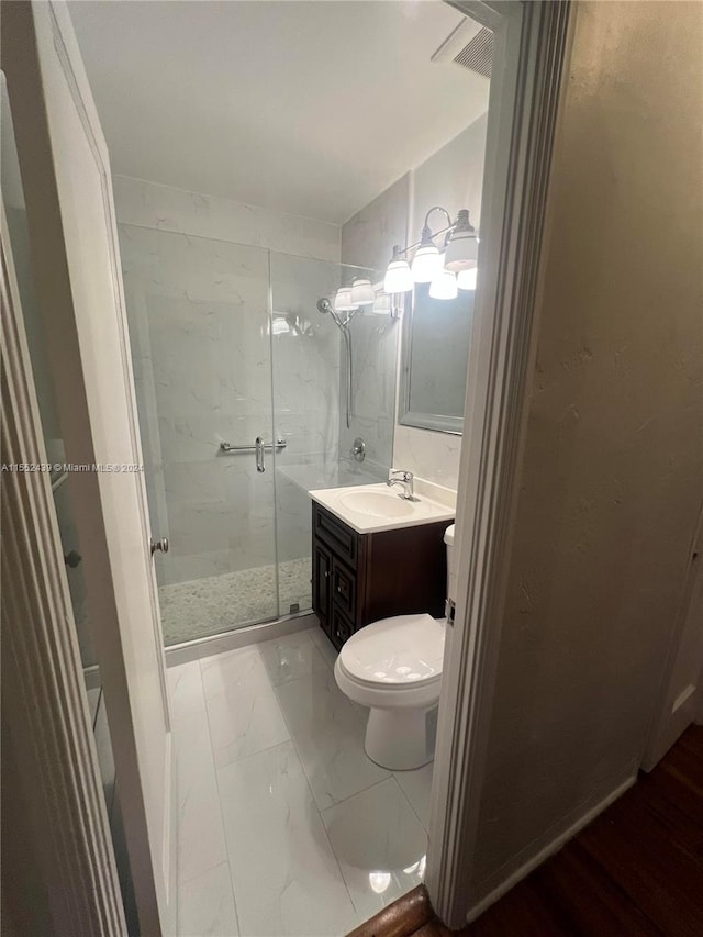 bathroom featuring vanity, walk in shower, and toilet