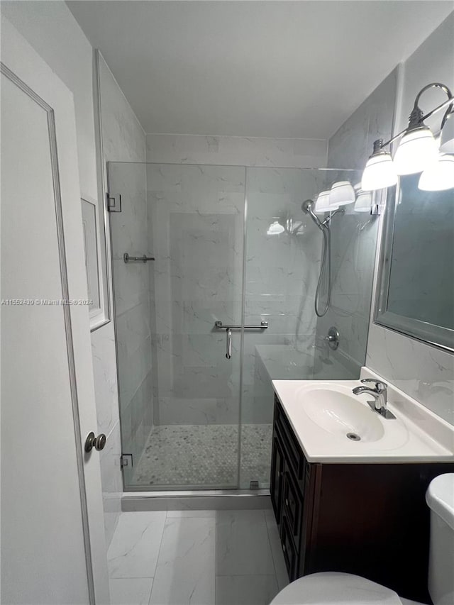 bathroom with vanity, a shower with shower door, and toilet