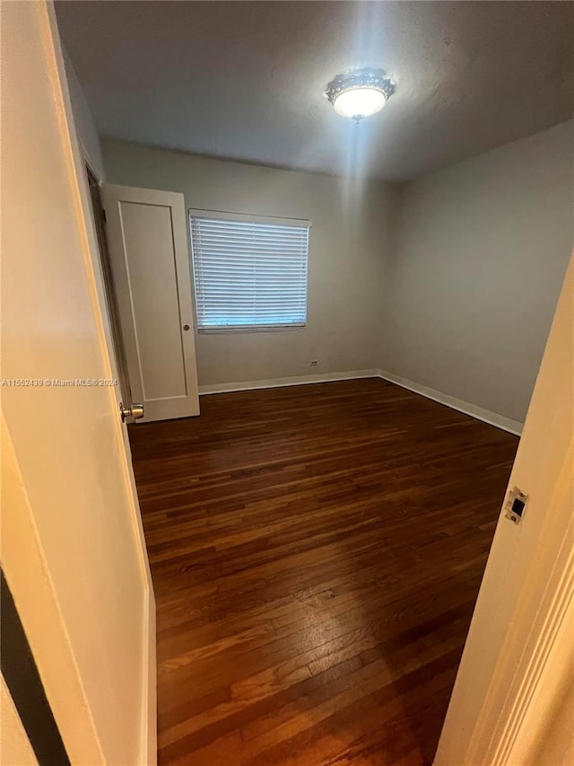 empty room with dark hardwood / wood-style floors