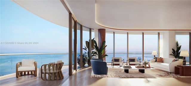 living room with expansive windows, hardwood / wood-style floors, and a water view