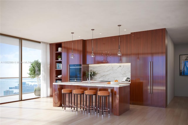 kitchen with light hardwood / wood-style floors, tasteful backsplash, a wealth of natural light, and hanging light fixtures