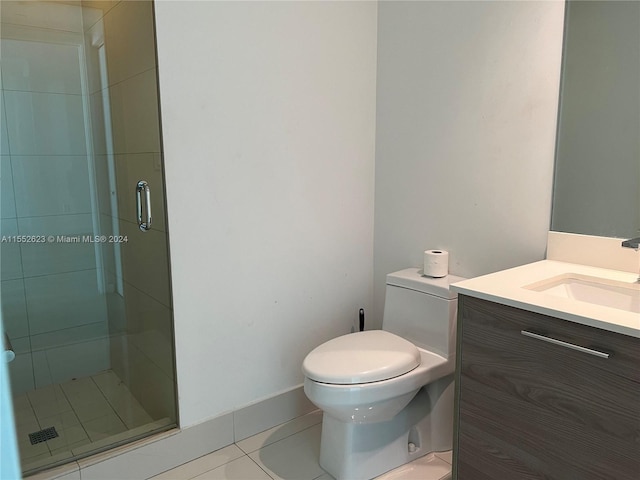 bathroom with toilet, tile floors, a shower with shower door, and oversized vanity