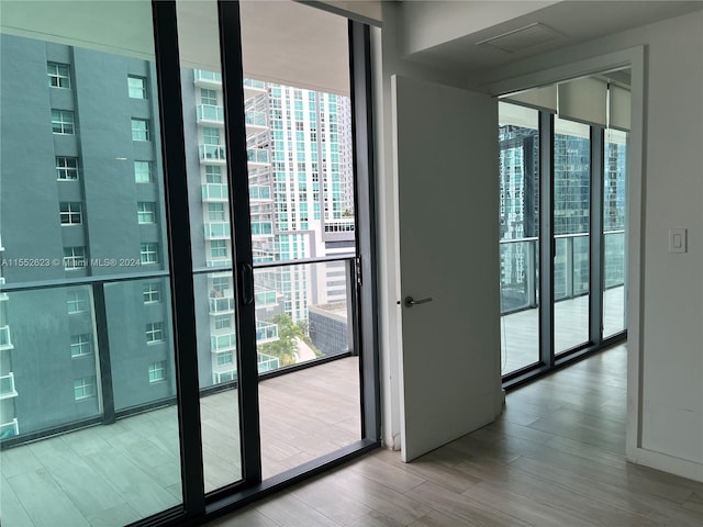 entryway featuring plenty of natural light, expansive windows, and light hardwood / wood-style flooring