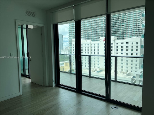 entryway with hardwood / wood-style flooring, floor to ceiling windows, and a wealth of natural light