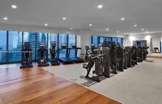 gym with a wealth of natural light and light wood-type flooring