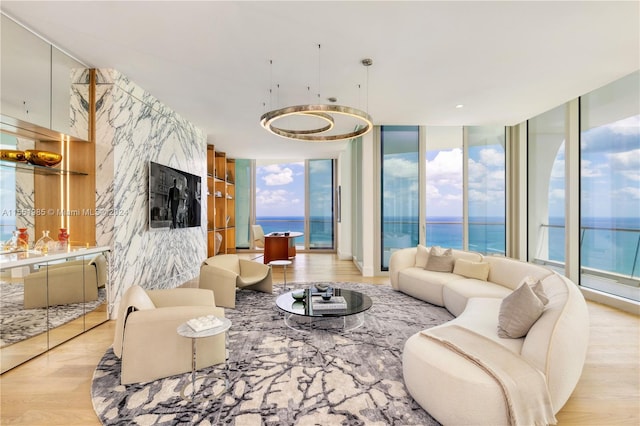 living room featuring a water view, light hardwood / wood-style floors, and expansive windows