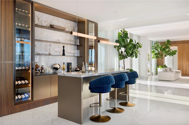 bar with decorative light fixtures, light tile floors, and stone counters