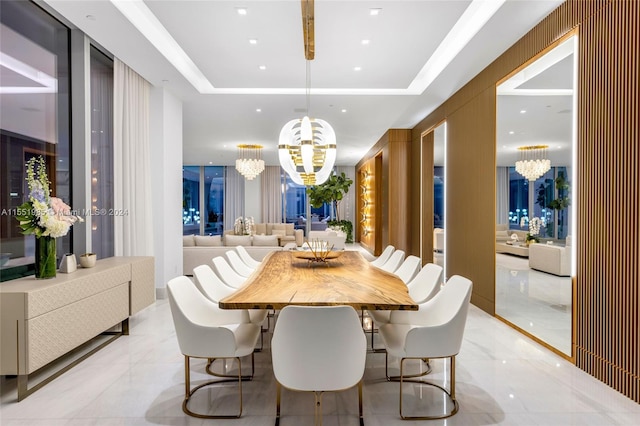 dining room featuring a raised ceiling, light tile flooring, and a chandelier