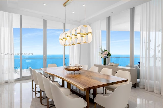 tiled dining space featuring a notable chandelier, expansive windows, and a water view