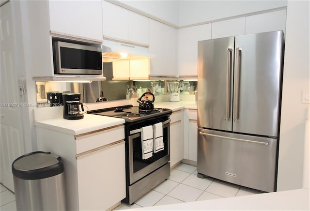 kitchen featuring white cabinets, stainless steel appliances, and light tile floors