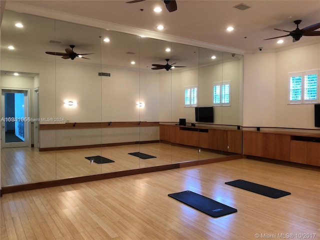 exercise area featuring plenty of natural light, ornamental molding, ceiling fan, and light wood-type flooring