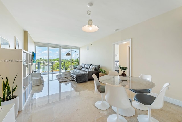 dining room featuring baseboards and floor to ceiling windows