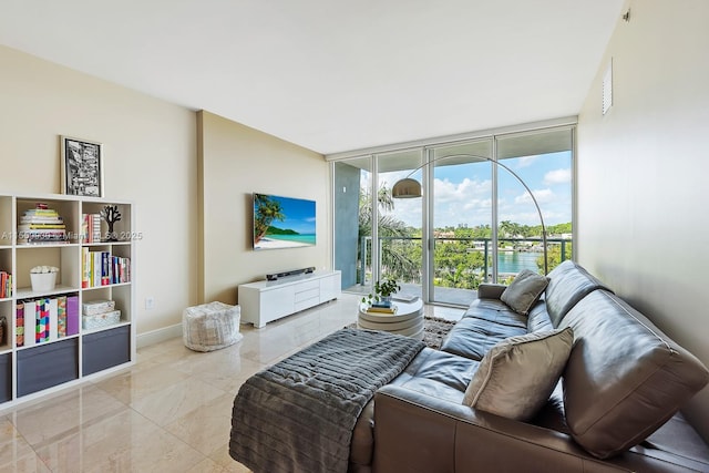 living area featuring a wall of windows, baseboards, and marble finish floor