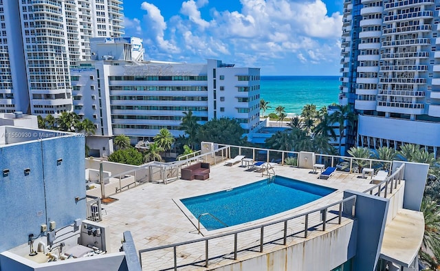 view of swimming pool featuring a patio and a water view