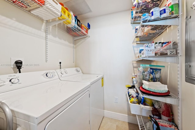 laundry room with light tile patterned flooring, laundry area, washing machine and dryer, and baseboards